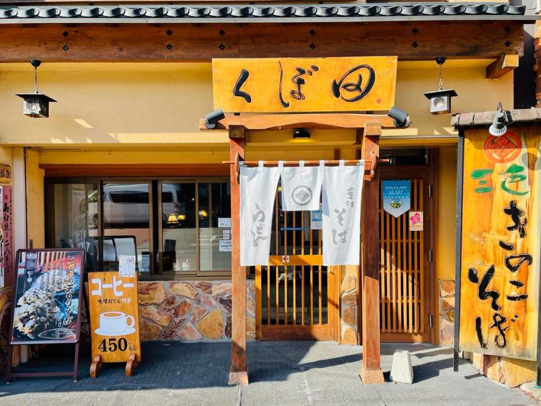 「そば処 くぼ田」は、水上駅前にお店をかまえ半世紀以上にもなる三代続く老舗のお蕎麦屋さんです。旅人達がみなかみへと足を踏み入れるその第一歩を、紺の暖簾をはためかせ、昔も今も変わらぬ味と共に見守り続けています。

観光客や地元の人達から愛されるくぼ田の蕎麦は、薄めの色合いが特徴的な二八そば。
「毎日食べても食べ飽きない、親しみのある味」と評判で、独特のもちっとしたコシのある蕎麦を噛みしめると、口の中に蕎麦の香りが広がります。

おいしさの秘訣。それは「蕎麦の50％を占める水」と「米づくり名人のつくった米粉」とのこと…？？